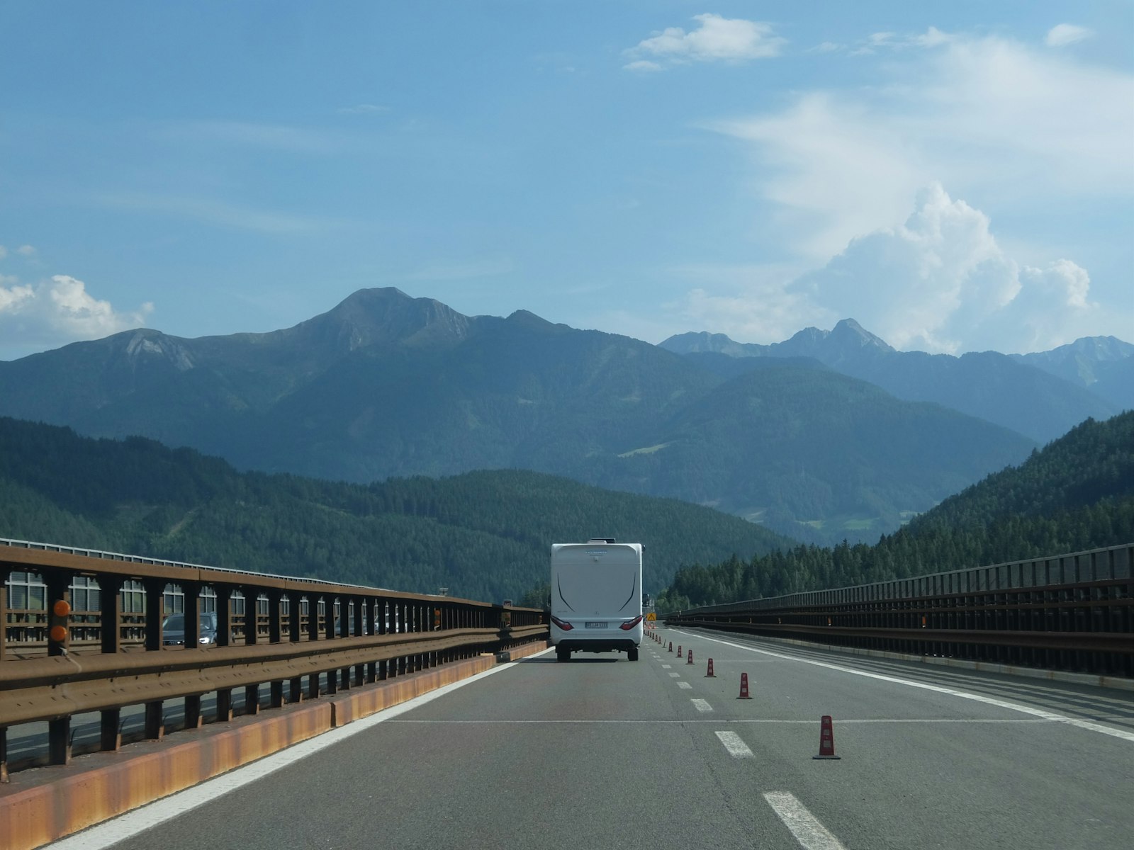 Camper in viaggio su un viadotto autostradale tra le montagne
