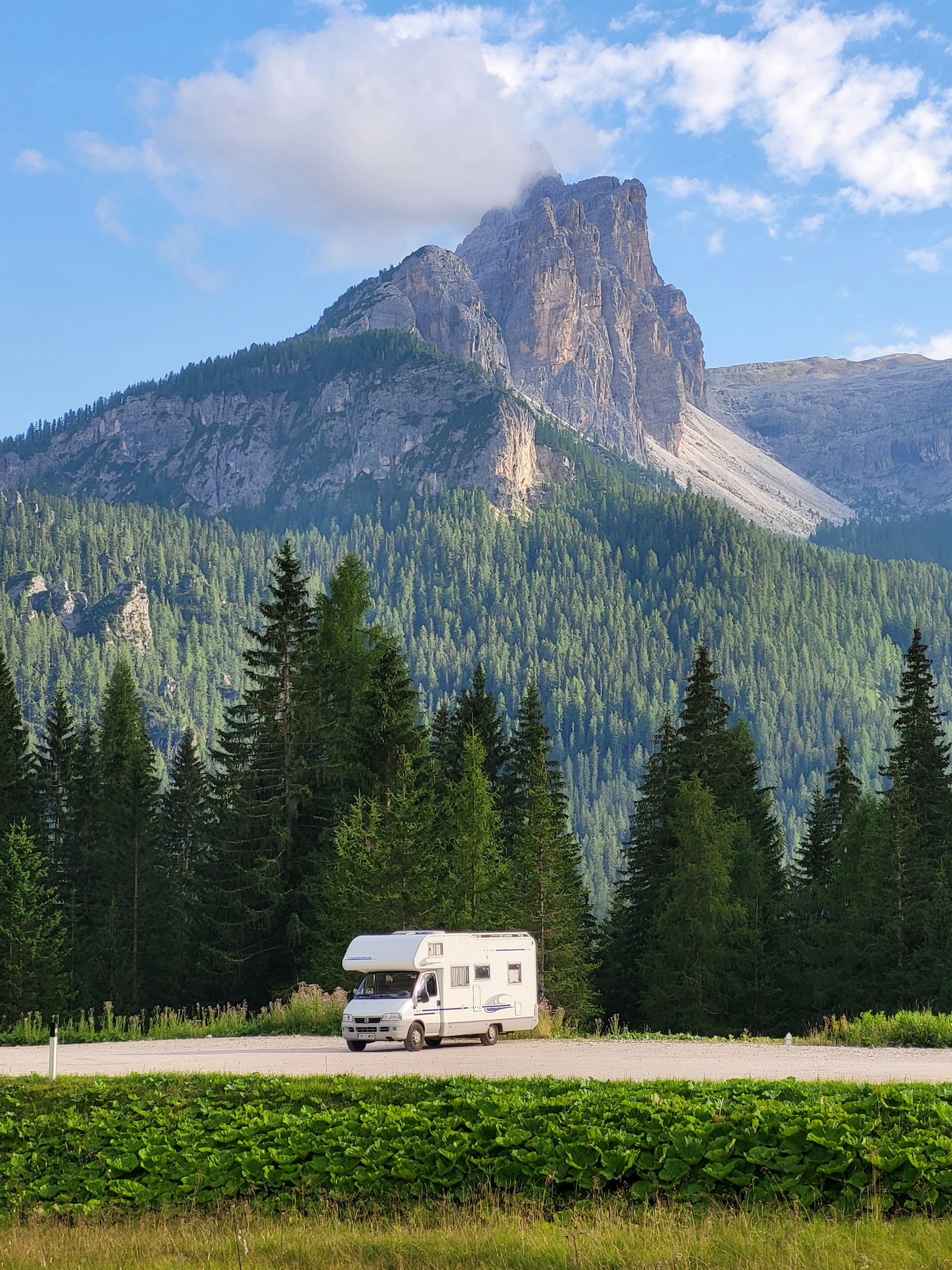 Camper parcheggiato ai piedi delle Dolomiti tra i boschi